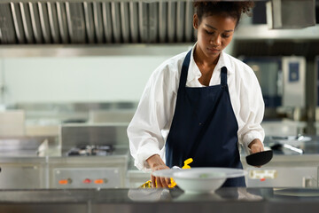 Fototapeta na wymiar Happy African American woman standing with arms crossed while working as chef in a restaurant. Cooking class. culinary classroom. happy young african woman students cooking in cooking school.