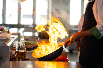 Thai Asian man professional chef cooking meal with fire at kitchen restaurant. culinary classroom....
