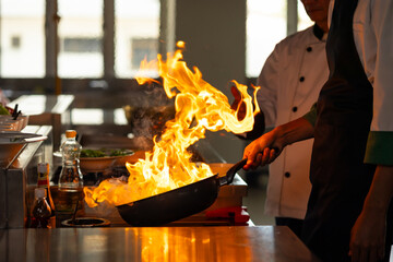 Thai Asian man professional chef cooking meal with fire at kitchen restaurant. culinary classroom....