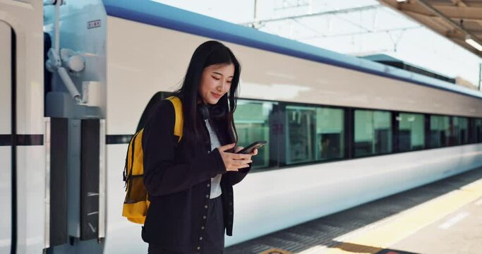 Asian woman, phone and train for travel, communication or social media at railway station. Female person smile with backpack or bag on mobile smartphone waiting for transportation, trip or traveling