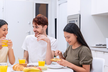 Obraz na płótnie Canvas Close-up of friends enjoying a conversation and breakfast in a modern kitchen.