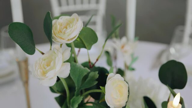 Beautiful fresh flowers are in a vase on the table. The camera captures them in motion in close-up