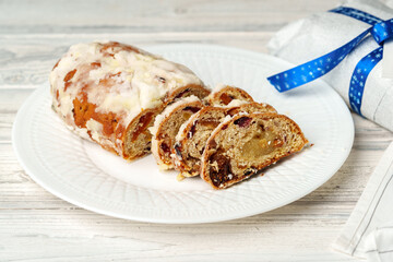 Christmas stollen on plate on white wooden table