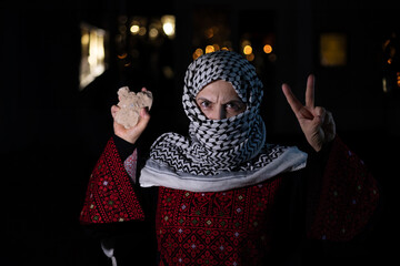 portrait for old woman holding stone which represents the only weapon against the occupation and...