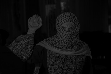 portrait for old woman holding stone which represents the only weapon against the occupation and will be the road to freedom