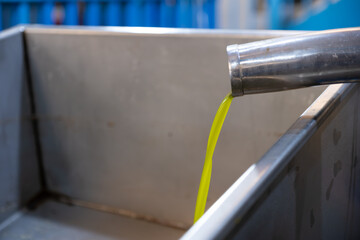 Stainless steel pipe pouring fresh virgin olive oil heat pressed