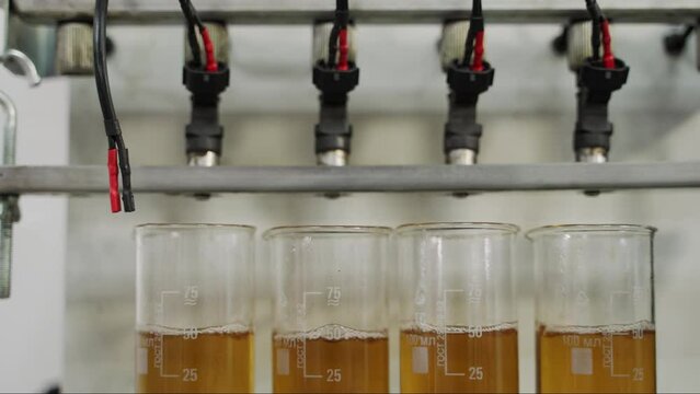 Automotive fuel injectors undergo ultrasonic cleaning process. Vehicle maintenance, precision nozzle spray restoration. Auto service efficiency, engine performance enhancement.