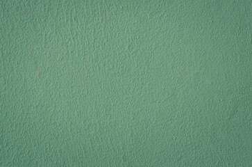 Fragment of a green plastered textured wall.
