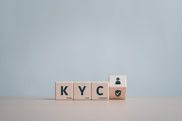 KYC word on wooden cubes with flipping customer and verify icons. Know your customer, verify the identity of customers and assess potential risks of illegal intentions for financial transactions