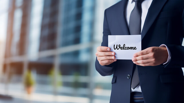 Businessman half portrait showing welcome note against the office building backdrop