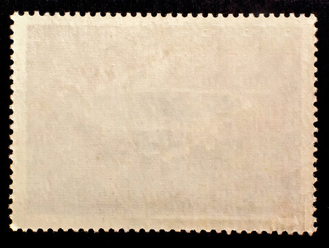 Blank aged postage stamp isolated on black background. Texture of paper. Template for graphic designers	