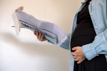 Pregnant female holding receipt on white background