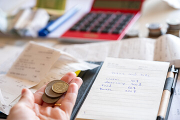 hands holding money from point of view in front of Table consist of money bills and medicine Organizer