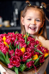 A little girl with a big bouquet of tulips. Beautiful bunch of flowers as a gift for Valentine's Day, Women's Day 8 March, birthday, holiday