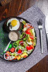 salad nicoise with vegetables and egg, on a plate, tablecloth on the table, dark and moody, top new