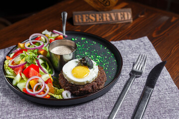 salad nicoise with vegetables and egg, on a plate, tablecloth on the table, dark and moody, top new