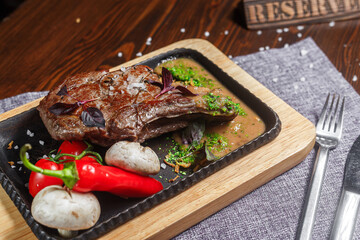 large piece of fried meat, steak with vegetables, on a plate, tablecloth on the table, dark and moody, top new