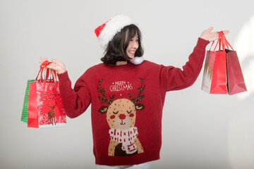 Young happy woman in santa claus hat wearing red sweater over white background, Christmas concept.
