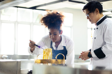 Happy African American woman scooking  and team working as chef in a restaurant. Cooking class. culinary classroom. happy young african woman students cooking in cooking school.