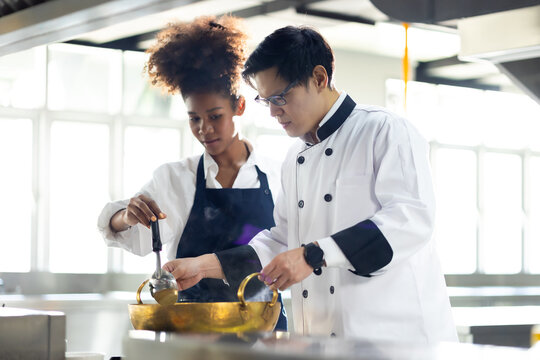 Group of student learning. Cooking class. culinary classroom. group of happy mature man and young woman multi - ethnic students are focusing on cooking lessons in a cooking school.