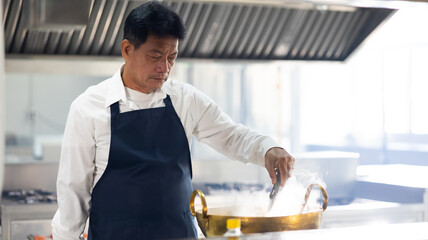 Mature master chef. Cooking class. portrait senior asian thai male professional chef cooking meal....