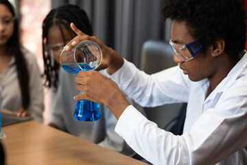 Diversity Teenage boys and girls are doing science experiments with lasks for chemistry in school...