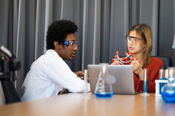 Diversity Teenage boys and girls are doing science experiments with lasks for chemistry in school chemistry classroom. chemistry class. Diverse student sci workshop