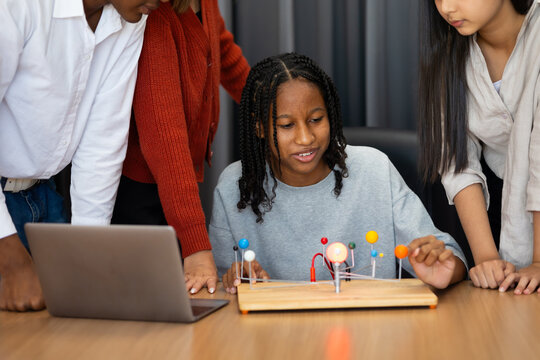 Group diverse students boy and girls looking at models solar system in an astronomy class. Dlectric planet models. chemistry class. Diverse student sci workshop