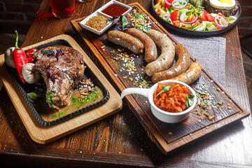 salad nicoise with vegetables, large piece of fried meat or steak, Nuremberg German sausages, dark and moody, top new