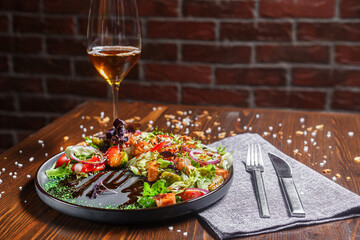 salad with grilled vegetables, roast beef on a black plate, dark and moody, top new