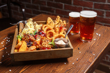 Beer basket with snacks, onion rings, country potatoes, chips, , dark and moody, top new