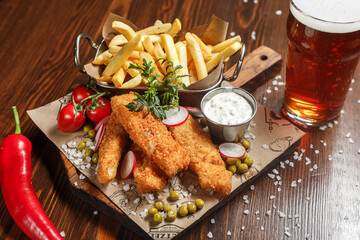 French fries, cheese sticks on a wooden board, beer and white sauce, dark and moody, top new