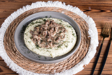 beef stroganoff with mashed potatoes on a plate. Serving a hot meat dish