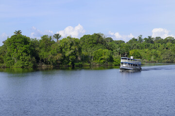 Traditional wooden boat navigating on the Madeira River, Amazonas State, Brazil