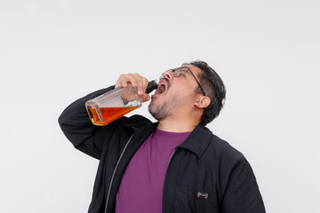 A drunk middle aged man gulping down an entire bottle of whiskey. Isolated on a white backdrop.