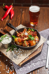 Fried potatoes with mushrooms and chicken in a cast iron frying pan, dark and moody, top new