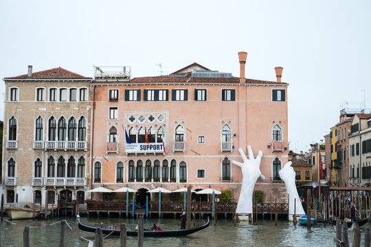 Venice, Italy - 20 May 2017 : 'Support', Two large hands emerging from the Grand Canal. It is Lorenzo Quinn's installation at the Ca’ Sagredo Hotel to highlight the climate change problem.