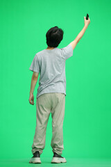 A guy in a gray T-shirt, on a green background, in full height, waving his phone