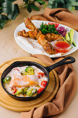 Fried salmon with creamy sauce and pork kebab on a wooden skewer