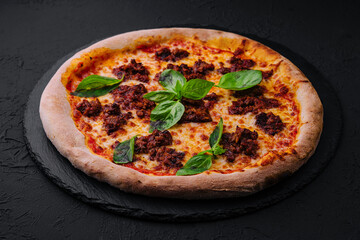 Pizza with minced meat and mozzarella on a stone board