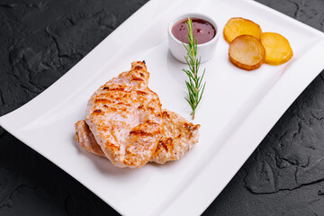 Grilled chicken breast with french fries slices of rustic