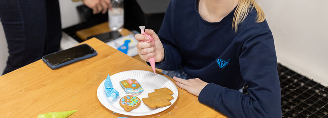 Children decorate gingerbread cookies for the New Year