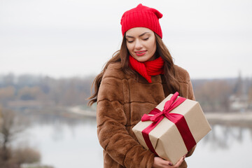 A young woman is holding a box in her hands