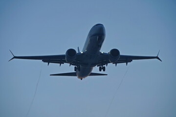 The plane is flying in the sunset evening sky.