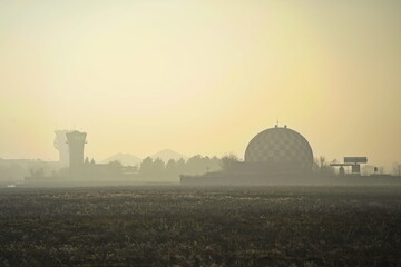 The runway area at sunset with fog and smog.