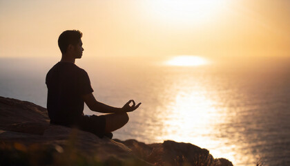 Silhouette of a man meditating on a cliff at sunset