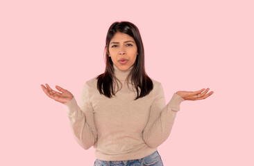 Young Indian woman in wool winter sweater showing both hands open palms, presenting and advertising...