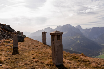 Remains of military bunker of First World War on mount Helm (Monte Elmo) with scenic view of mountain peaks of untamed Sexten Dolomites, South Tyrol, Italy, Europe. Wanderlust concept in Italian Alps - obrazy, fototapety, plakaty