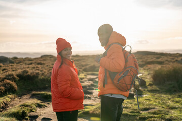 Portrait of happy couple in love walking along countryside at the sunset.  Love, hiking and active lifestyle concept