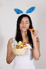 Beautiful woman with bunny ears with a basket of Easter desserts